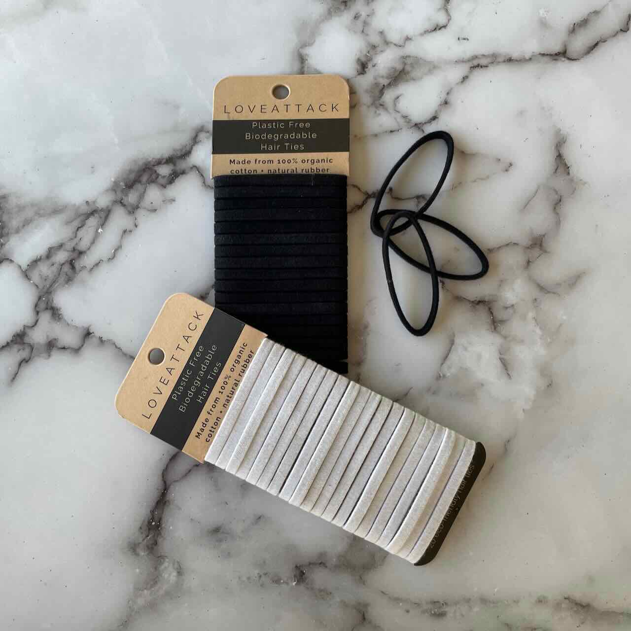 white hair tie set on top of a set of black hair tie