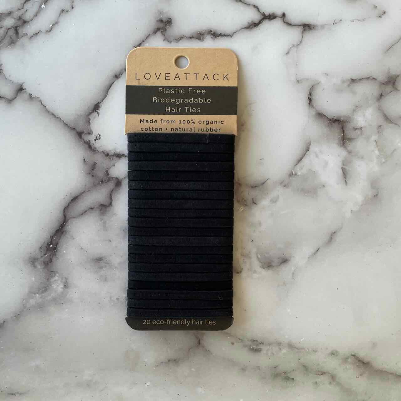 a pack of black hair ties lying on top of a marble patterned table