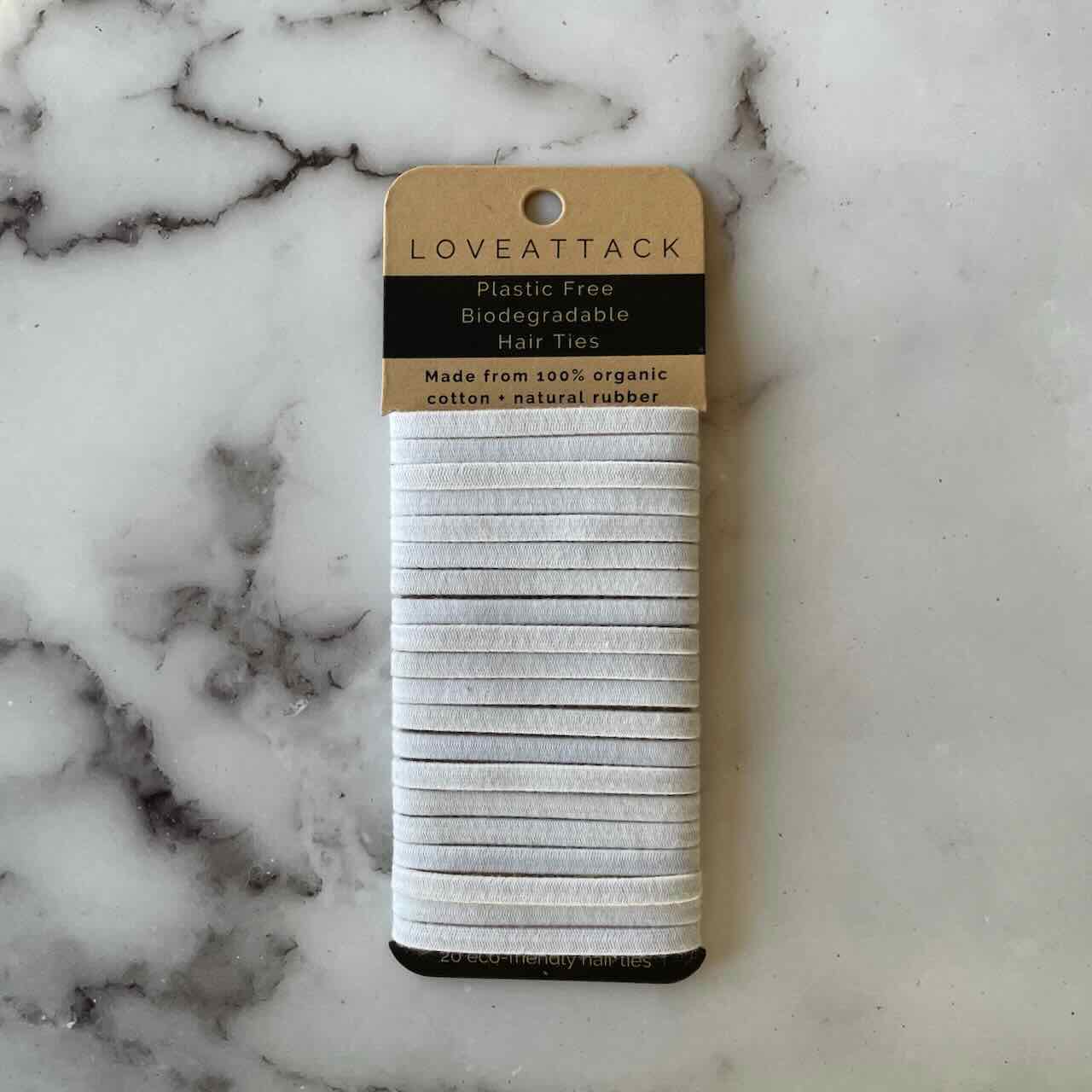 a pack of white hair ties lying on top of a marble patterned table