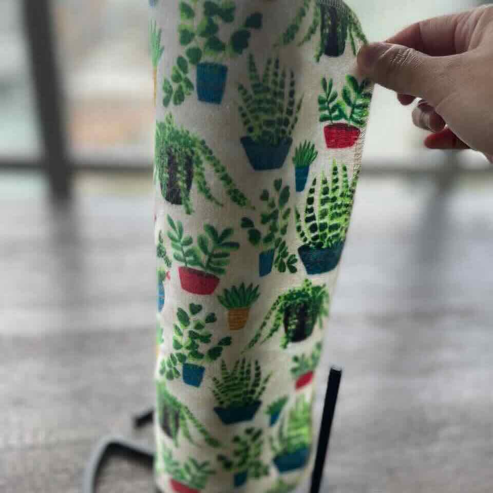 Cactus patterned non paper towel rolled up and is on a paper towel holder