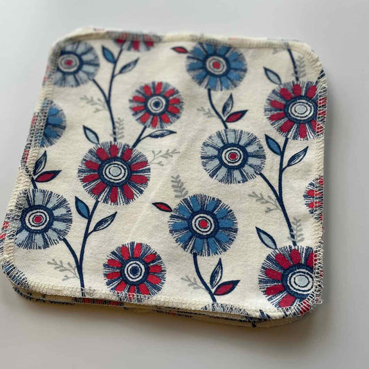 flat lay of a set of 10 reusable cloth wipes, with vibrant flower patterns printed on the fabric.