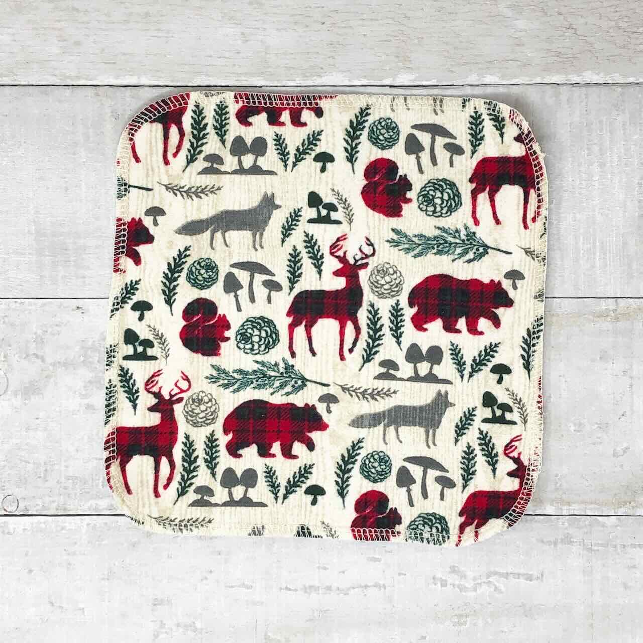 flat lay of a set of 10 reusable cloth wipes, with vintage woodland animals like bears, foxes and dears printed on the fabric.