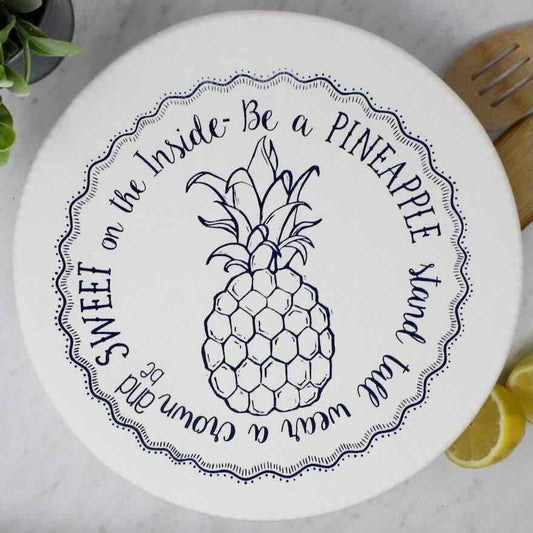 Flat lay of an extra large bowl covered by a waxed pineapple patterned bowl cover on a wooden chopping board.