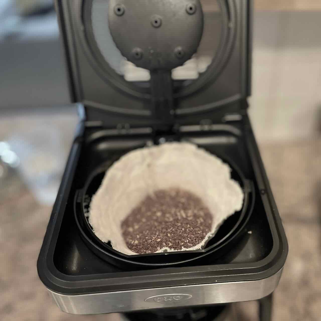 size 4 coffee filter filled with ground coffee inside basket in the coffee maker