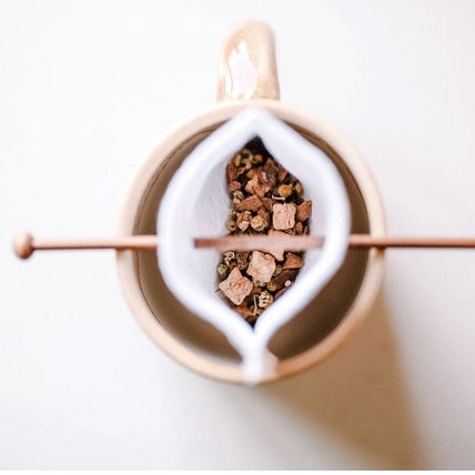 Ariel view of the inside of a reusable white cotton tea bag filled with herbal tea